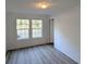Bright bedroom with two windows, light vinyl floors, and neutral-colored walls at 5181 Dr Taylor Rd, Adams Run, SC 29426