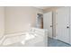 Bathroom features a soaking tub with tile flooring and white door access to upper level at 5429 Roxbury Dr, North Charleston, SC 29418