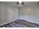 A simple bedroom with gray walls, wood floors, ceiling fan, and a white door with white closet doors at 6211 Rolling Fork Rd. # 1504 Apt D, North Charleston, SC 29406