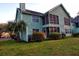 A two story home with green siding and a screened in porch, surrounded by a green lawn and palm trees at 6211 Rolling Fork Rd. # 1504 Apt D, North Charleston, SC 29406