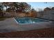 A square community pool surrounded by a concrete deck and a tall fence, in need of cleaning and maintenance at 6211 Rolling Fork Rd. # 1504 Apt D, North Charleston, SC 29406