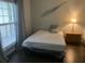 Bright bedroom with a bed covered in plastic wrap, next to a window and table at 700 Daniel Ellis Dr # 11202, Charleston, SC 29412