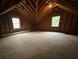 Unfinished attic space with exposed beams, plywood flooring, and windows for natural light at 827 Duck Hawk Retreat, Charleston, SC 29412