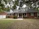 Charming red brick home with a well-manicured lawn, dormer windows, and inviting front porch at 827 Duck Hawk Retreat, Charleston, SC 29412