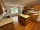 Spacious kitchen with wood cabinets, center island, stainless steel sink and hardwood floors at 827 Duck Hawk Retreat, Charleston, SC 29412