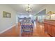 Open dining room with hardwood floors, a view into the kitchen, and a view into the entry at 8757 E Fairway Woods Dr, North Charleston, SC 29420