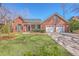 Charming brick home featuring a two-car garage, lush front lawn, and inviting front porch at 8757 E Fairway Woods Dr, North Charleston, SC 29420