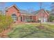 Beautiful brick home with a well-manicured lawn, inviting front porch, and a two-car garage at 8757 E Fairway Woods Dr, North Charleston, SC 29420