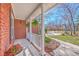 Charming front porch featuring hanging ferns, white railing and a brick facade at 8757 E Fairway Woods Dr, North Charleston, SC 29420