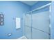 View of a bathroom with frosted shower doors and a white towel hanging from a silver towel rack on a blue wall at 106 Sea Lavender Ln, Summerville, SC 29486