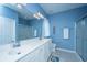 Bathroom with double sink vanity and mirror with a shower enclosed with glass doors in blue interior design at 106 Sea Lavender Ln, Summerville, SC 29486