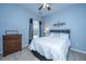 Cozy bedroom with a comfortable bed, a wooden dresser, and a window with grey and black curtains on a blue wall at 106 Sea Lavender Ln, Summerville, SC 29486