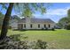 View of the back of the house from the backyard featuring a screened-in porch and lush lawn at 107 Ranworth Ln, Summerville, SC 29485