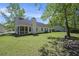 Wide backyard view showing the home's exterior, screened-in porch, and tree-shaded surroundings at 107 Ranworth Ln, Summerville, SC 29485