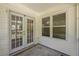 Covered patio with white trim, double doors, and a window showcasing a bright outdoor space at 107 Ranworth Ln, Summerville, SC 29485