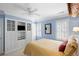 Bright bedroom with blue walls, custom built-ins, white shutters, and comfortable carpet at 108 Smith St # 108-C, Charleston, SC 29403