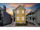 Exterior front view of a two-story yellow home with a porch and a sunset sky at 108 Smith St # 108-C, Charleston, SC 29403