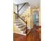 Bright entryway with wooden staircase, gleaming hardwood floors, and a glimpse into an adjacent room at 108 Smith St # 108-C, Charleston, SC 29403