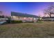 Backyard exterior of a brick home with a well-kept lawn and garden areas at twilight at 110 Dunbury Dr, Summerville, SC 29485