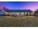 Exterior backyard brick home with a well-maintained lawn and an inviting patio area at twilight at 110 Dunbury Dr, Summerville, SC 29485