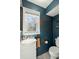 Charming half bathroom features teal walls, orange accents, a window, and a classic white toilet at 110 Dunbury Dr, Summerville, SC 29485