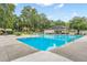 Large community pool area featuring plenty of seating, lush foliage, and a sunny sky at 110 Dunbury Dr, Summerville, SC 29485