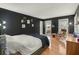 Bright main bedroom features hardwood floors, dark accent wall, chair and ottoman, and bedside lamps at 110 Dunbury Dr, Summerville, SC 29485