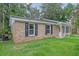 Side view of a single-story brick house with black shutters and green lawn at 112 Pine Grove Dr, North Charleston, SC 29420