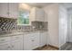 Kitchen featuring a decorative backsplash, white cabinets, and modern appliances at 112 Pine Grove Dr, North Charleston, SC 29420