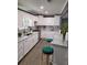 Well-lit kitchen featuring white cabinetry, granite countertops, stainless steel appliances, and trendy emerald bar stools at 1186 French Santee Rd, Jamestown, SC 29453