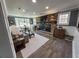 Well-lit living room featuring a brick fireplace, hardwood floors, large windows, and comfortable seating arrangements at 1186 French Santee Rd, Jamestown, SC 29453