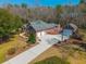 Aerial view of a sprawling brick home with a long driveway, two garages, and lush landscaping at 121 Arrowridge Ct, Summerville, SC 29485