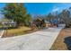 View of a red brick house, detached garage, mature trees and long driveway on a sunny day at 121 Arrowridge Ct, Summerville, SC 29485