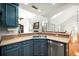 Modern kitchen showcasing a stainless steel sink, granite countertops, and stylish blue cabinets, blending style and functionality at 121 Arrowridge Ct, Summerville, SC 29485