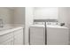 Laundry room with utility sink, cabinets, and modern washer and dryer set at 121 Arrowridge Ct, Summerville, SC 29485