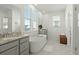 Bright bathroom with double sinks, large windows, and a freestanding tub at 1368 Clay Field Trl, Summerville, SC 29485
