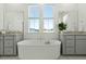 Soaking tub framed by double sinks and bright windows in well-lit bathroom at 1368 Clay Field Trl, Summerville, SC 29485