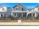 Charming blue two-story home with a covered porch and black picket fence under a bright blue sky at 1368 Clay Field Trl, Summerville, SC 29485