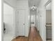 Hallway featuring wood-look flooring, white shiplap walls, white doors, and access to various rooms at 1368 Clay Field Trl, Summerville, SC 29485