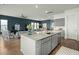 Open concept kitchen island with granite countertop, sink, and seating area flowing into the living and dining spaces at 1368 Clay Field Trl, Summerville, SC 29485