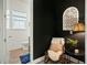 Chic powder room with black accent wall, stylish decor, and modern fixtures near a chair with pillows at 1368 Clay Field Trl, Summerville, SC 29485