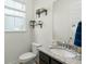 Bright powder room with granite countertop, dark wood cabinets, and decorative shelves and window with blinds at 1368 Clay Field Trl, Summerville, SC 29485