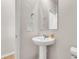Small half bathroom with a pedestal sink, mirror and lighting. There is a door to the left of the sink at 141 Woodland Oak Way, Summerville, SC 29485
