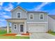 Charming two-story home featuring a covered front porch and an attached two-car garage at 141 Woodland Oak Way, Summerville, SC 29485