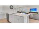 Modern kitchen with a large island and sink, seamlessly connecting to the adjacent living and dining areas at 141 Woodland Oak Way, Summerville, SC 29485