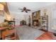 Cozy living room featuring a stone fireplace, ceiling fan, and bright natural light from the windows at 159 Bridgecreek Dr, Goose Creek, SC 29445