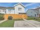 Exterior view of the home's backyard with a parking area and yellow fence at 1717 Brittlebush Ln, Johns Island, SC 29455