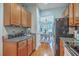 Well-lit kitchen with wood cabinets and stainless steel appliances overlooks an open dining area at 1717 Brittlebush Ln, Johns Island, SC 29455