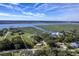 Aerial view of sprawling waterfront property with lush landscape, complemented by stunning water views and established trees at 185 Wappoo Rd, Charleston, SC 29407