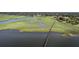 An aerial view of a property with a long pier leading out into the water and green marsh views at 185 Wappoo Rd, Charleston, SC 29407